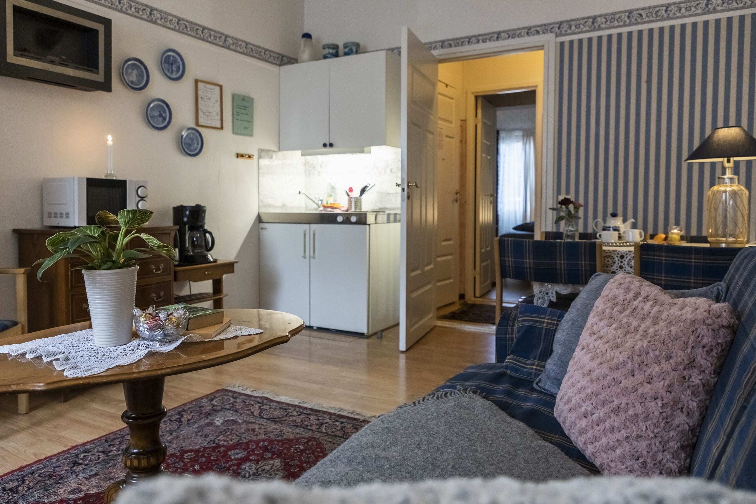 Een woonkamer met een bank, een salontafel en een keuken op de achtergrond.
