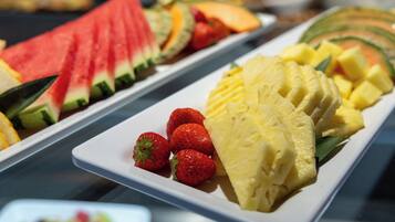 Un buffet con anguria a fette, ananas e fragole.