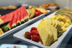 Un buffet proposant des tranches de pastèque, d’ananas et de fraises.