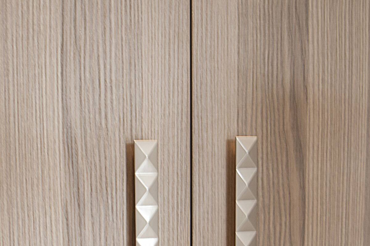 A wooden door with two vertical handles.