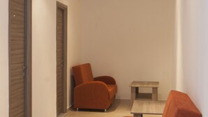 A narrow hallway with two orange armchairs and a small table. - Pension Pineapple (Skiathos)