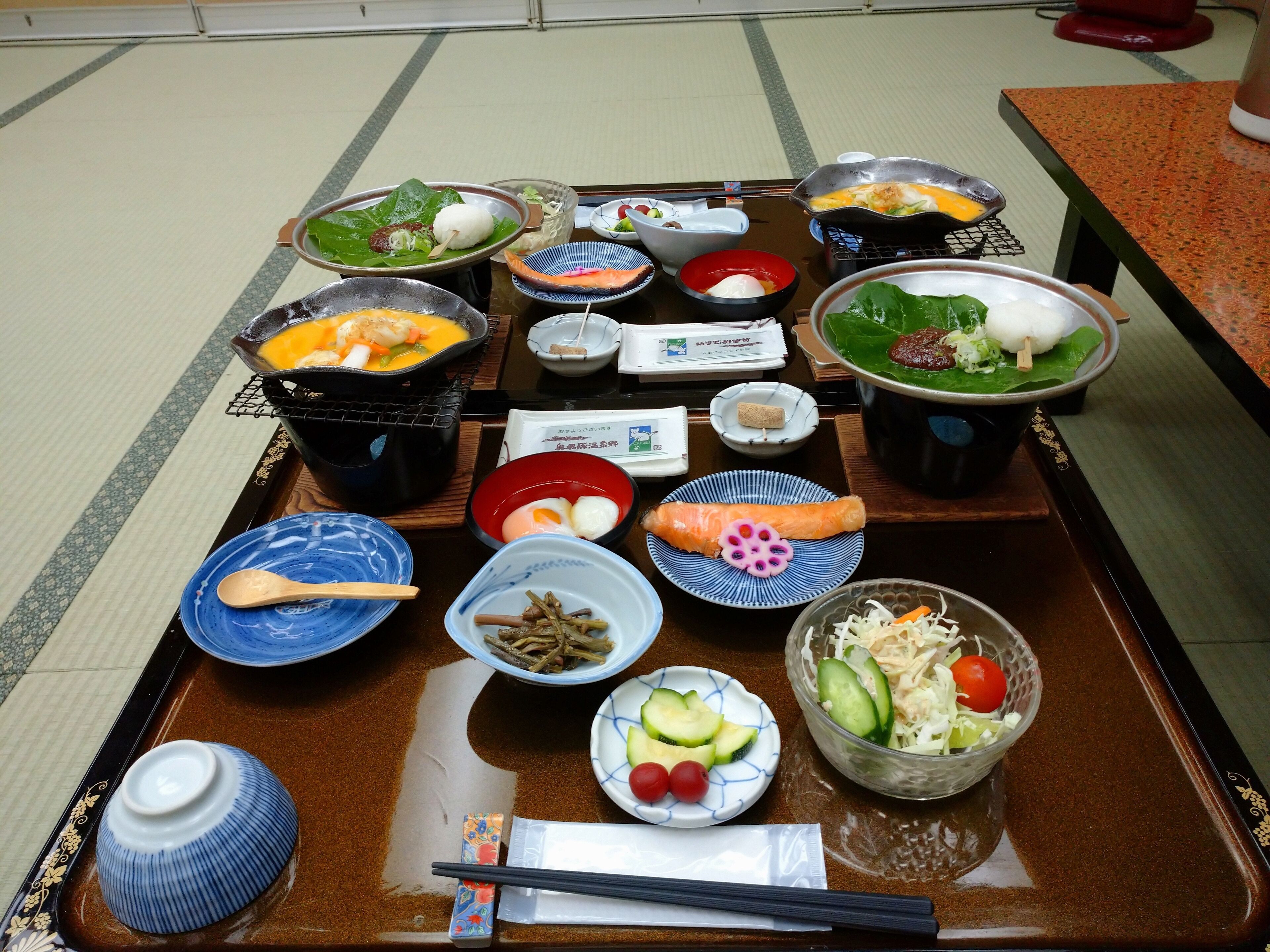 Una comida tradicional japonesa con diversos platos y utensilios sobre una bandeja.