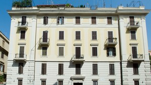 Un edificio de varios pisos con balcones, ventanas amplias y techo plano.