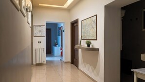 Un pasillo con un radiador, un mostrador de recepción y un mapa enmarcado en la pared.