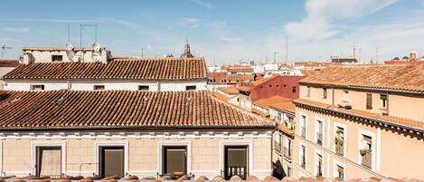 A view of terracotta-tiled rooftops and buildings with multiple windows and balconies.