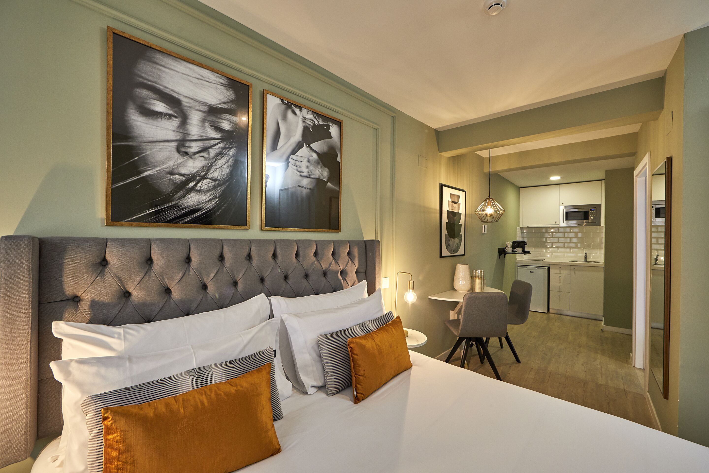 Un dormitorio con una cama grande, un comedor y una cocina.