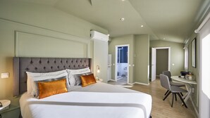 A modern hotel room with a large bed, a desk, and a chair. - L&H La Latina (Madrid)