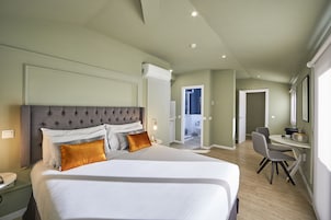 Una moderna camera d'hotel con un letto grande, una scrivania e una sedia.