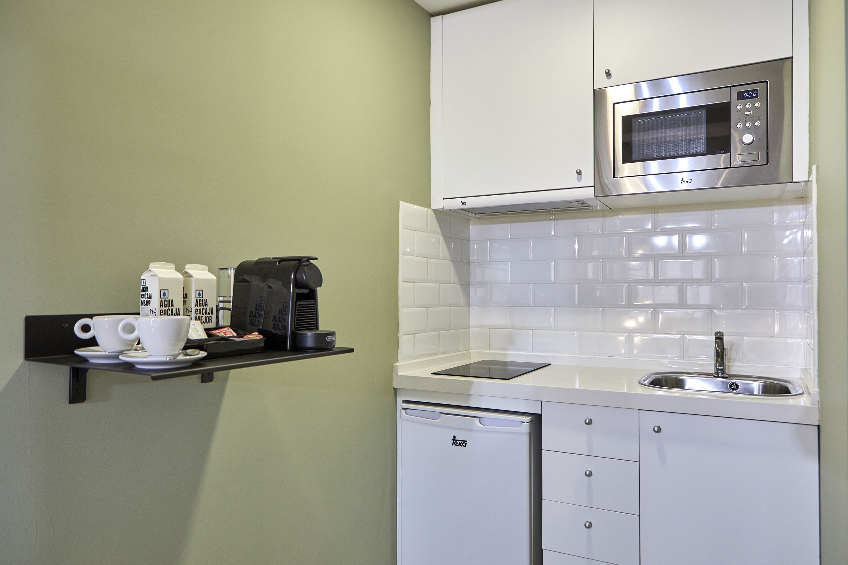 A compact kitchen with a microwave, coffee maker, and a dishwasher.