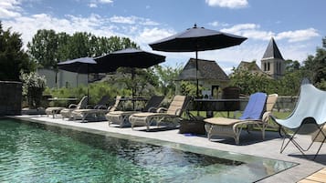 Una piscina techada, una piscina al aire libre de temporada, sombrillas