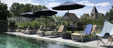 Una piscina techada, una piscina al aire libre de temporada, sombrillas