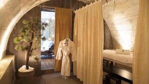 Une pièce chaleureuse avec un plafond en bois, un lit, un peignoir et un arbre en pot.