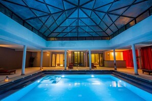Una piscina al aire libre, sombrillas, tumbonas