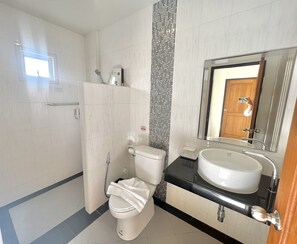A modern bathroom with a toilet, sink, and shower. - JS Residence Krabi (Krabi)