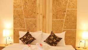 A hotel room with a large bed, two pillows, two bedside lamps, and two towels arranged on the bed. - JS Residence Krabi (Krabi)