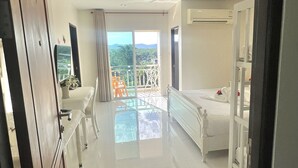 A modern hotel room with a balcony, a bed, a bathroom, and a view of the outdoors. - JS Residence Krabi (Krabi)