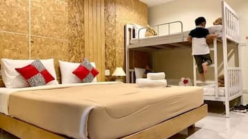 Quarto de hotel com uma cama de solteiro, uma cama grande e uma parede de madeira.