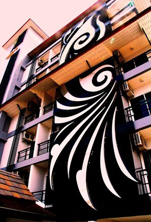 Edifício com várias andares, varandas e aparelhos de ar condicionado.