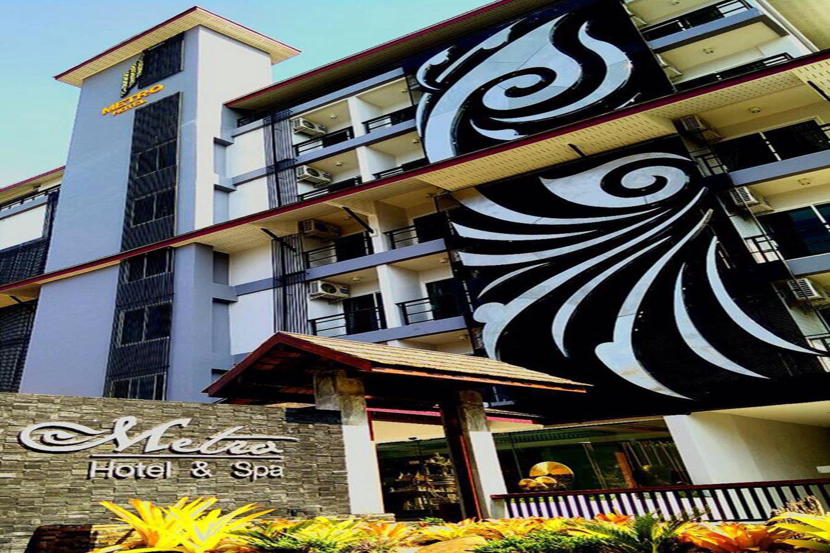 A hotel with a modern facade, multiple balconies, and a distinctive black and white decorative element.