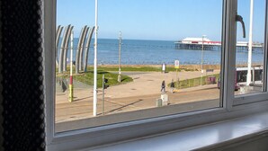 A view of a coastal area with a pier, a bus, and a pedestrian path.