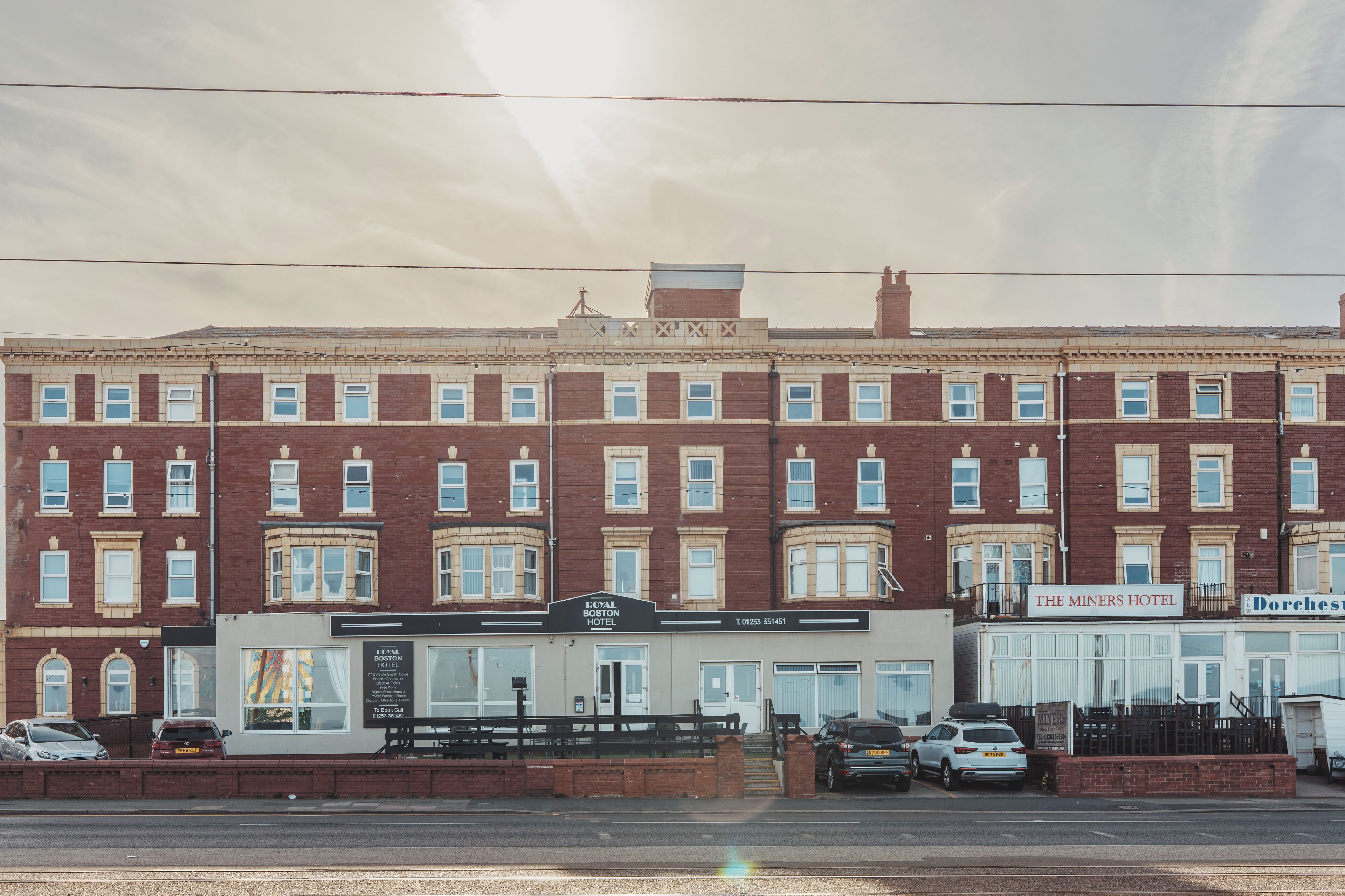 A row of red brick buildings with The Miners Hotel and Dorchester Hotel signs.