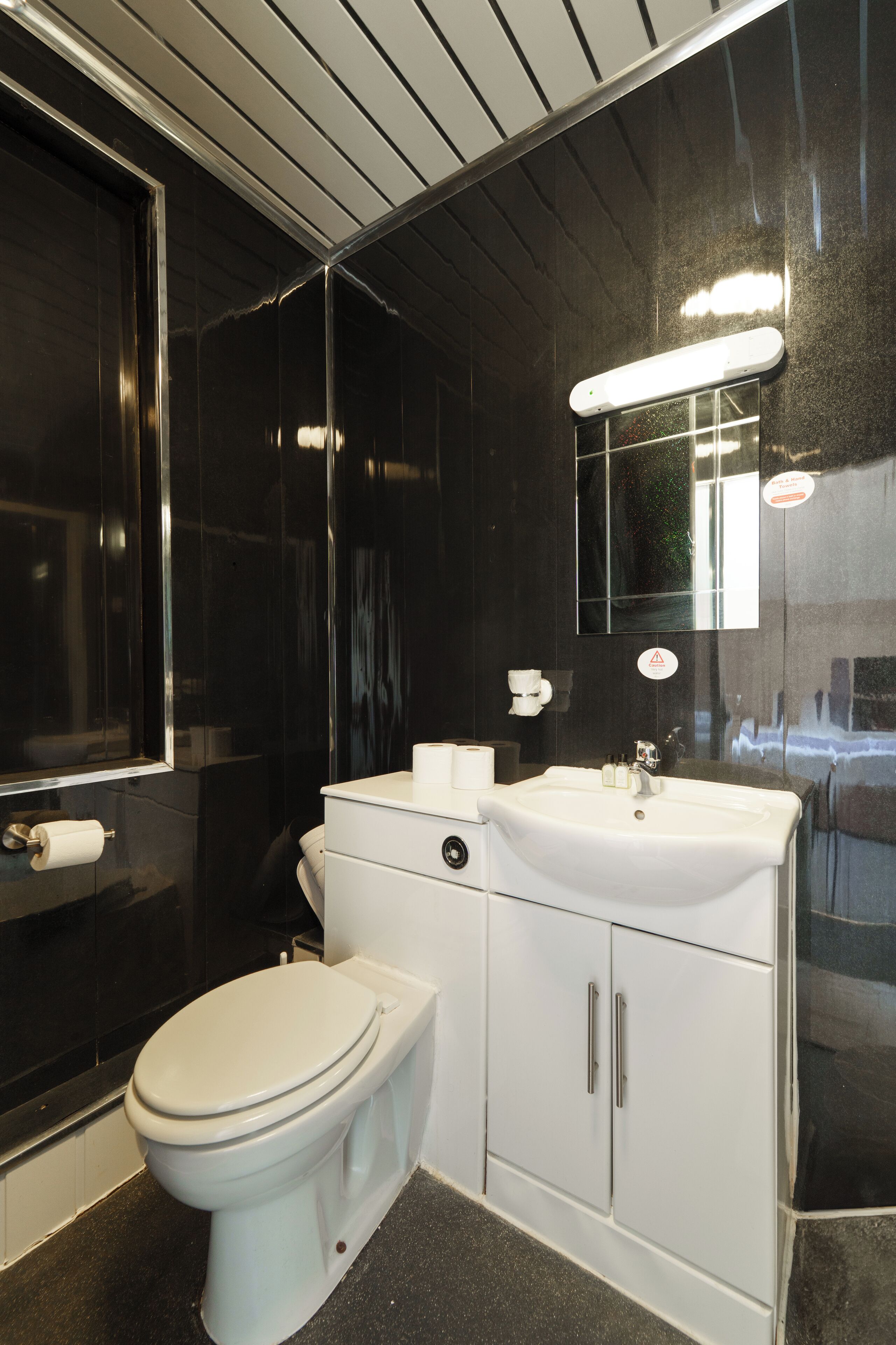 A modern bathroom with a white toilet, a sink, and a mirror.