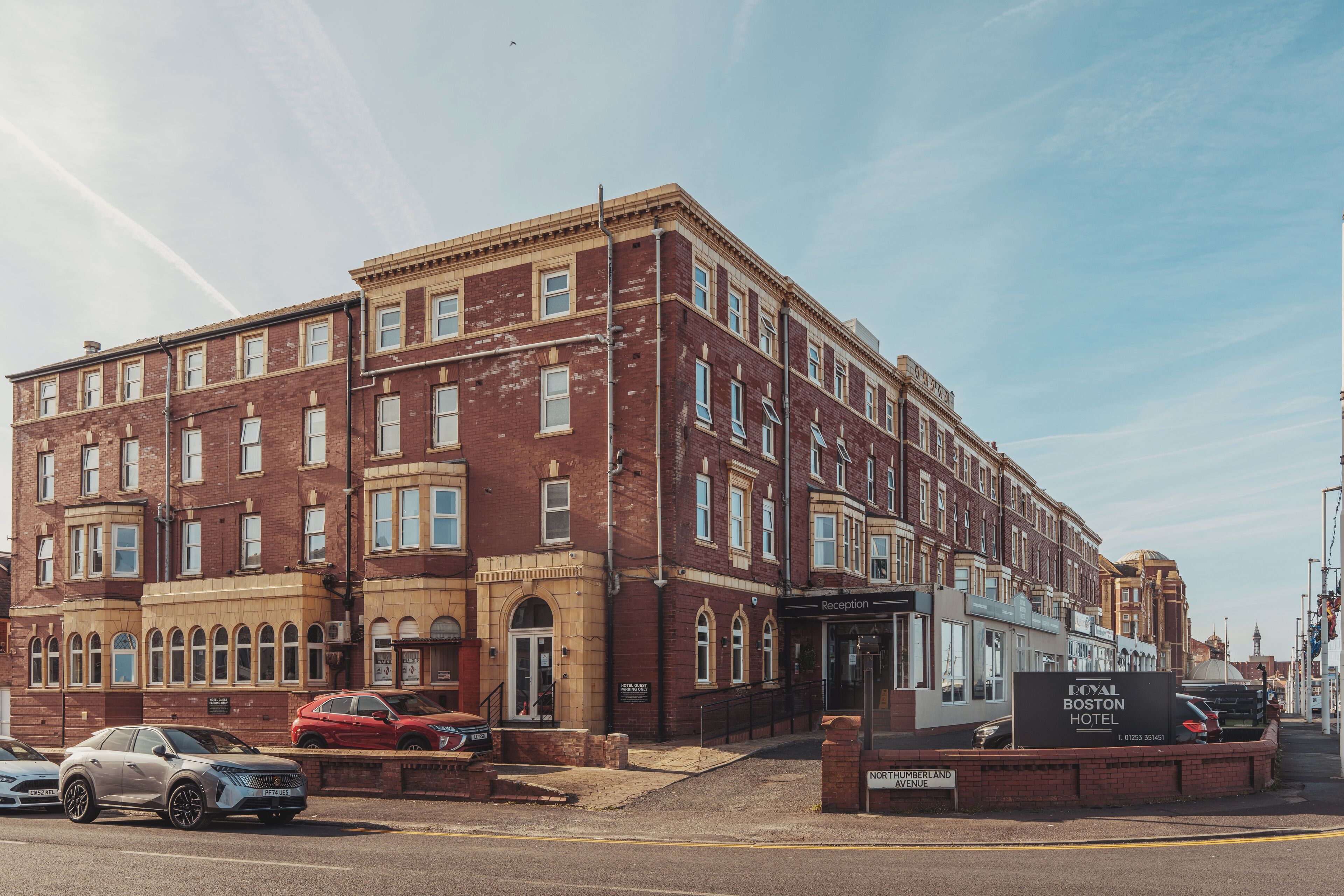 A historic red brick building with a reception area and a sign for the Royal Boston Hotel.