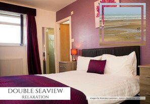 A double seaview room with a bed, a nightstand, a lamp, and a view of the beach. - The Royal Carlton Hotel (Blackpool)