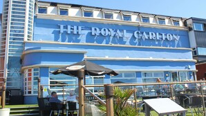 Een gebouw met het bord "The Royal Carlton", dat een hotel aangeeft.