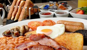 A breakfast plate with eggs, bacon, mushrooms, tomatoes, beans, toast, and sausages. - The Royal Carlton Hotel (Blackpool)