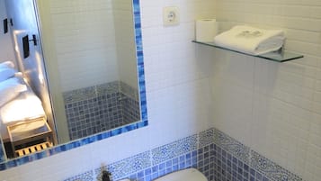 Un baño con lavamanos, inodoro y espejo con marco azul.