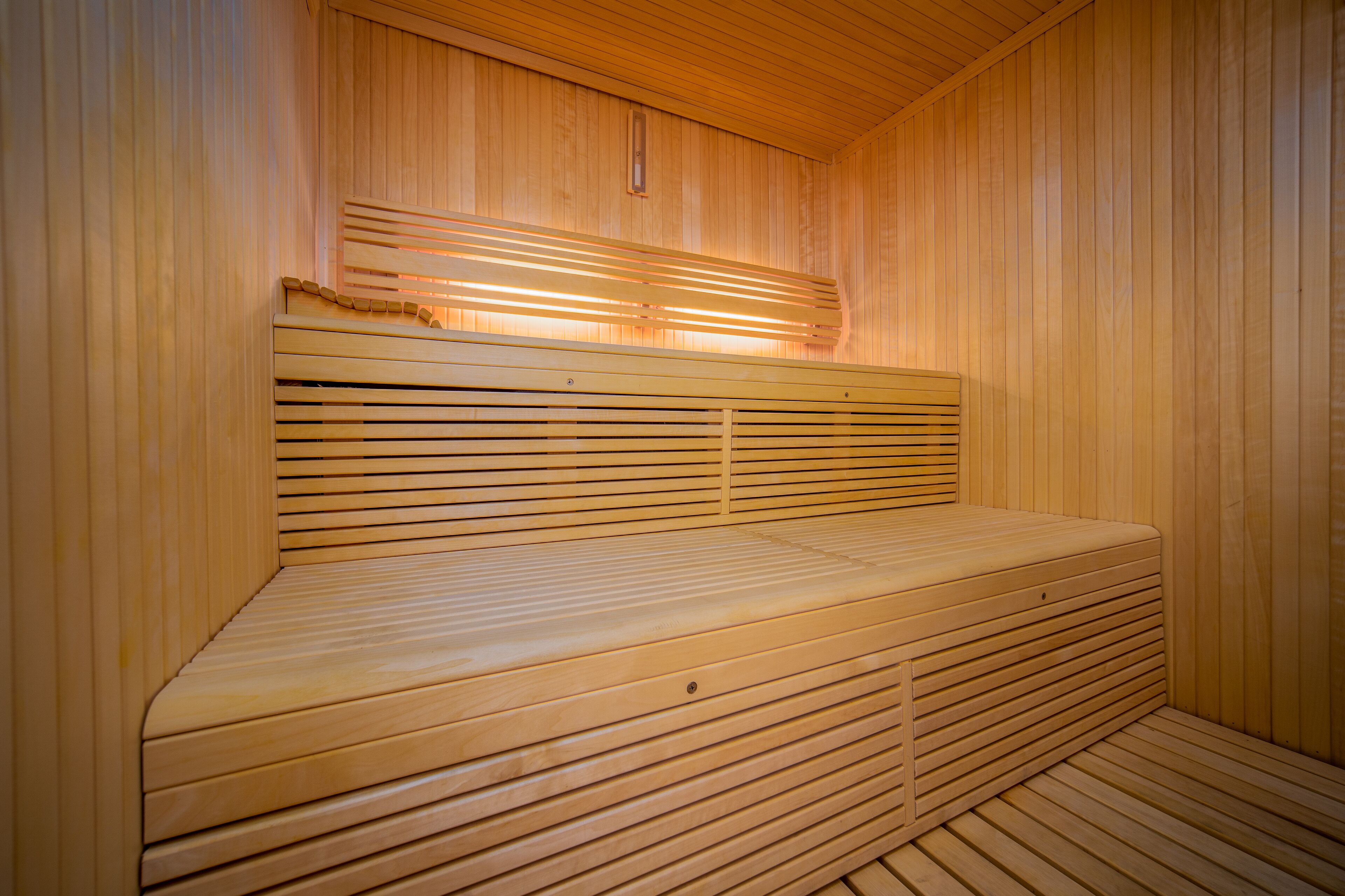 A sauna with wooden benches and slatted backrests.