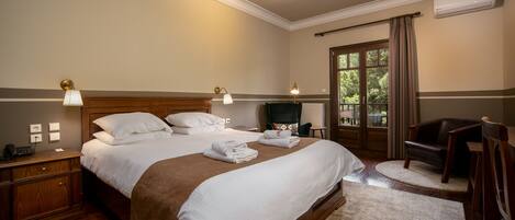 A neatly arranged bedroom with a large bed, bedside lamps, a chair, and a view of the outdoors through a window.
