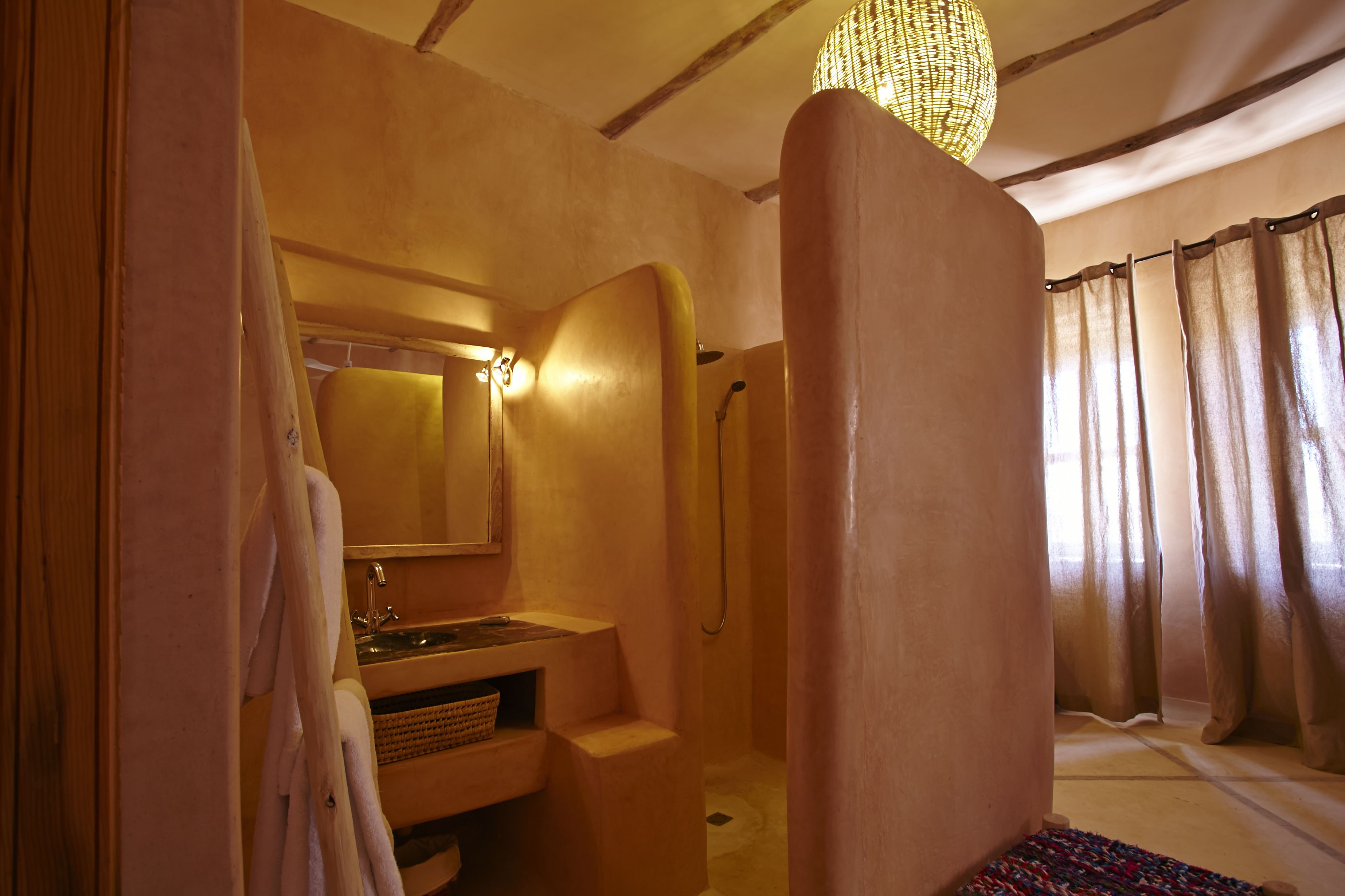 Un baño con lavamanos, espejo y zona de ducha.