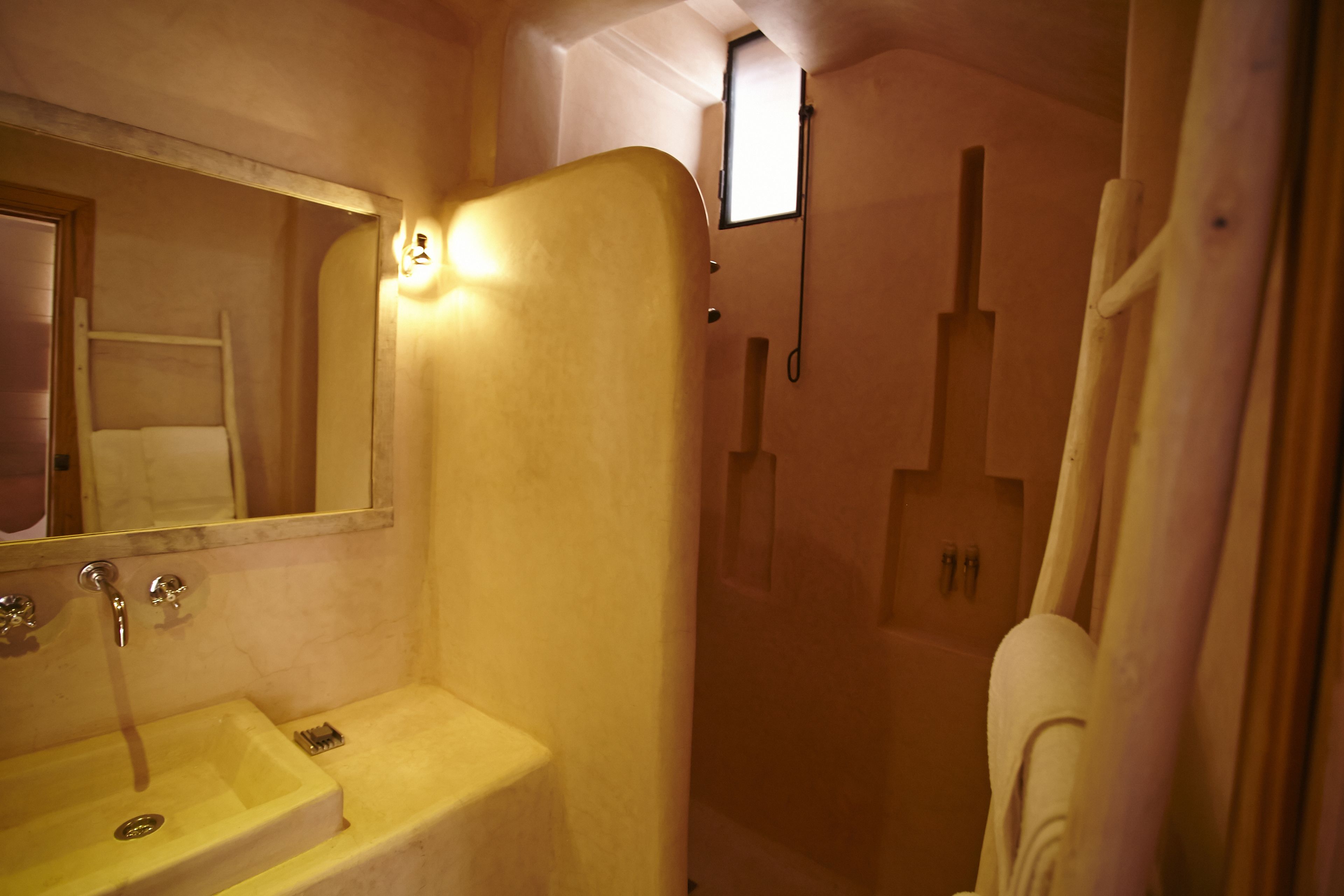 Un baño con lavamanos, espejo y ducha.