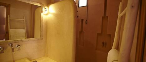 Un baño con lavamanos, espejo y ducha.