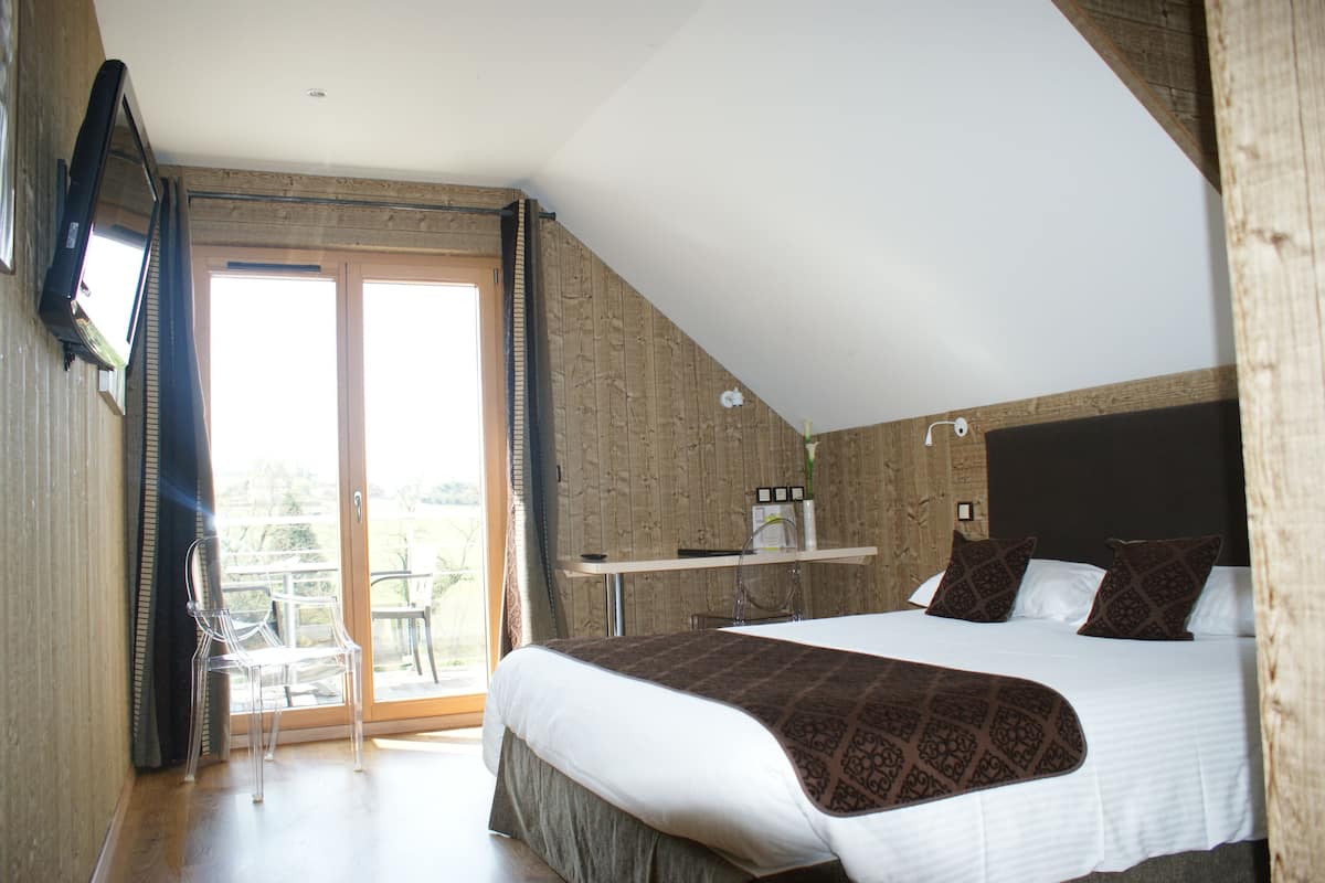 A bedroom with a bed, a desk, and a chair.