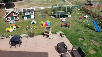 Children can play and explore in this spacious play area featuring two playhouses, a trampoline, and multiple slides.