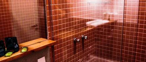 A bathroom with a sink, mirror, and shower enclosure.