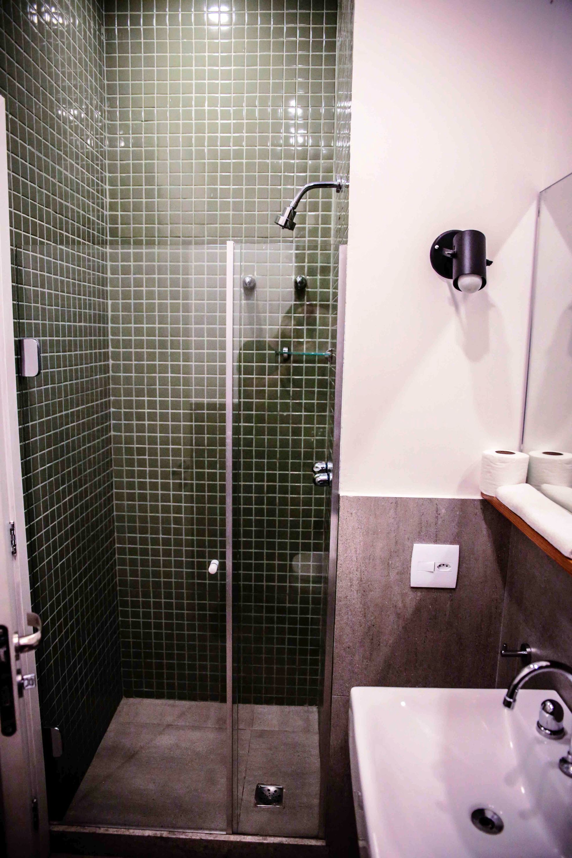 Un baño con cabina de ducha de vidrio, un lavabo e inodoro.