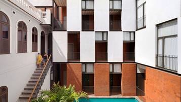 A multi-story building with a central courtyard featuring a swimming pool.