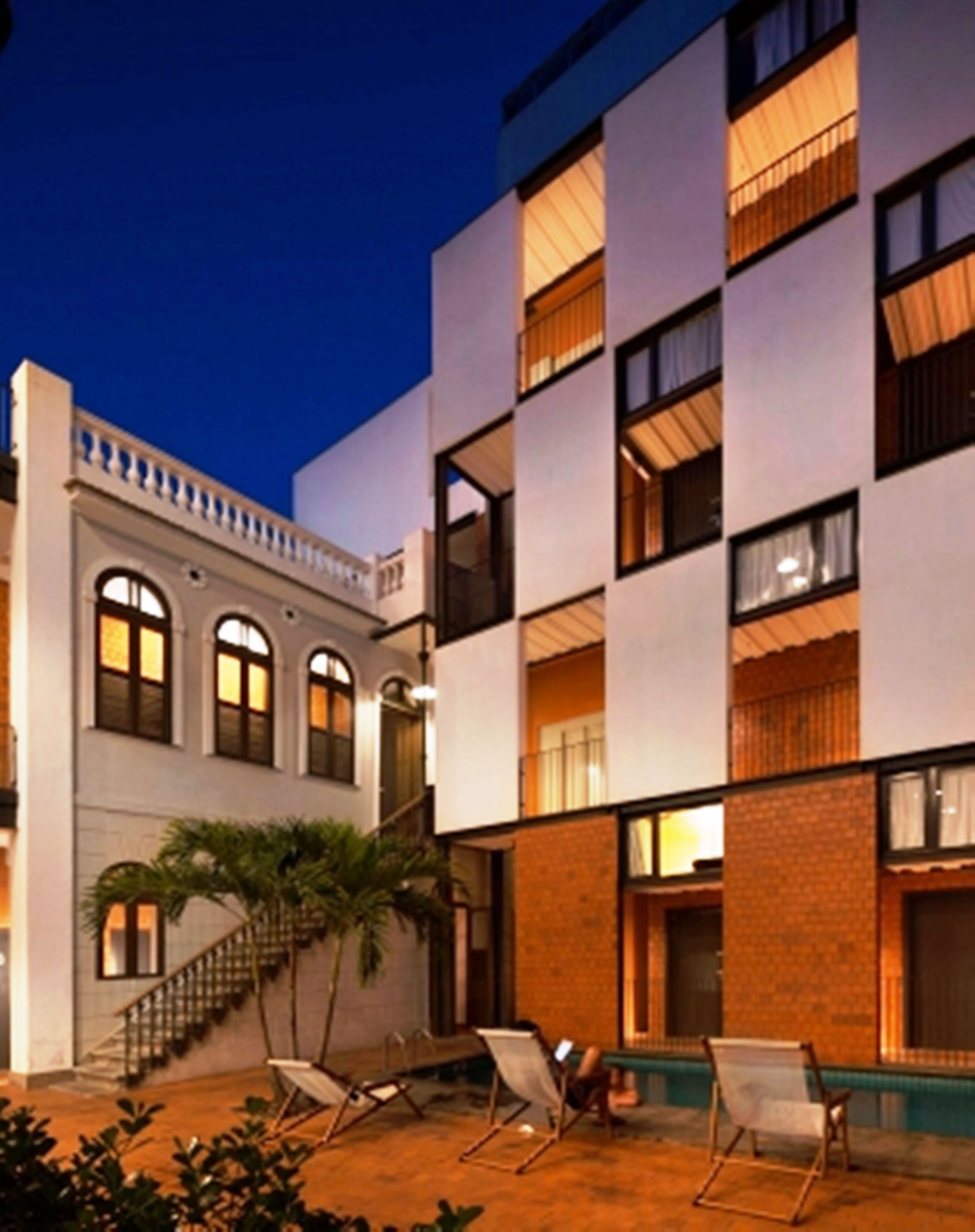 A multi-story building with a modern design, featuring balconies and large windows.