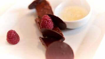 A dessert plate with chocolate-covered strawberries and a small bowl of cream.