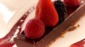 Dessert med jordbær, hindbær og brombær på en chokoladesovse.