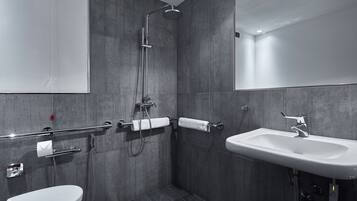 Un baño moderno con ducha, inodoro y lavamanos.