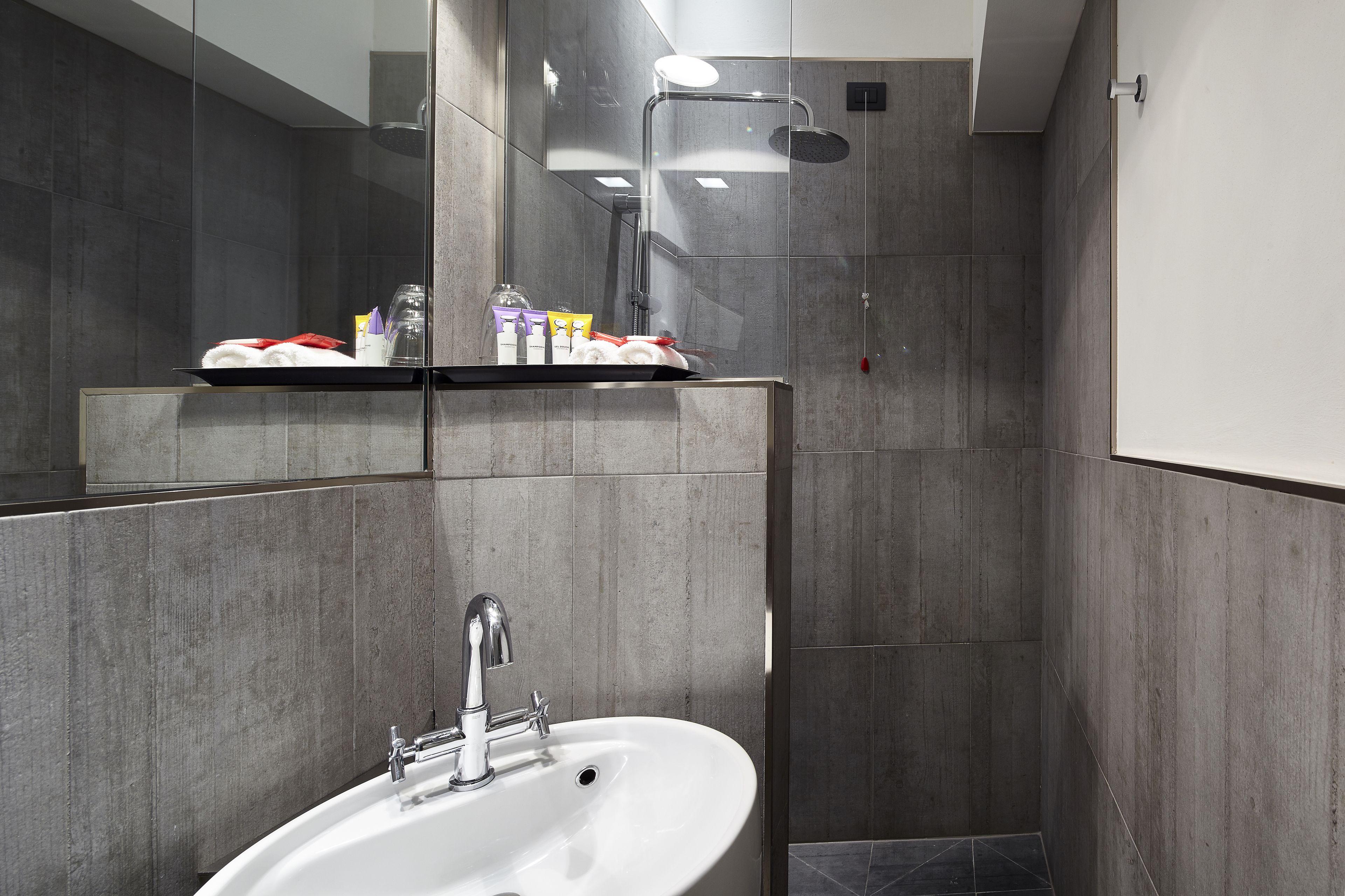 Ein modernes Badezimmer mit Waschbecken, Spiegel und Dusche.