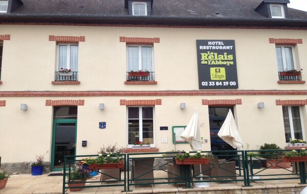 Ein Hotel mit Schild, das es als Hotel und Restaurant ausweist, genannt "Le Relais de l'Abbaye", inklusive Kontaktdaten.