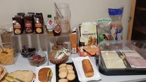 A buffet table with various food items including bread, pastries, and a variety of condiments. - Hôtel le Relais de l'Abbaye (Saint-Evroult-Notre-Dame-du-Bois)