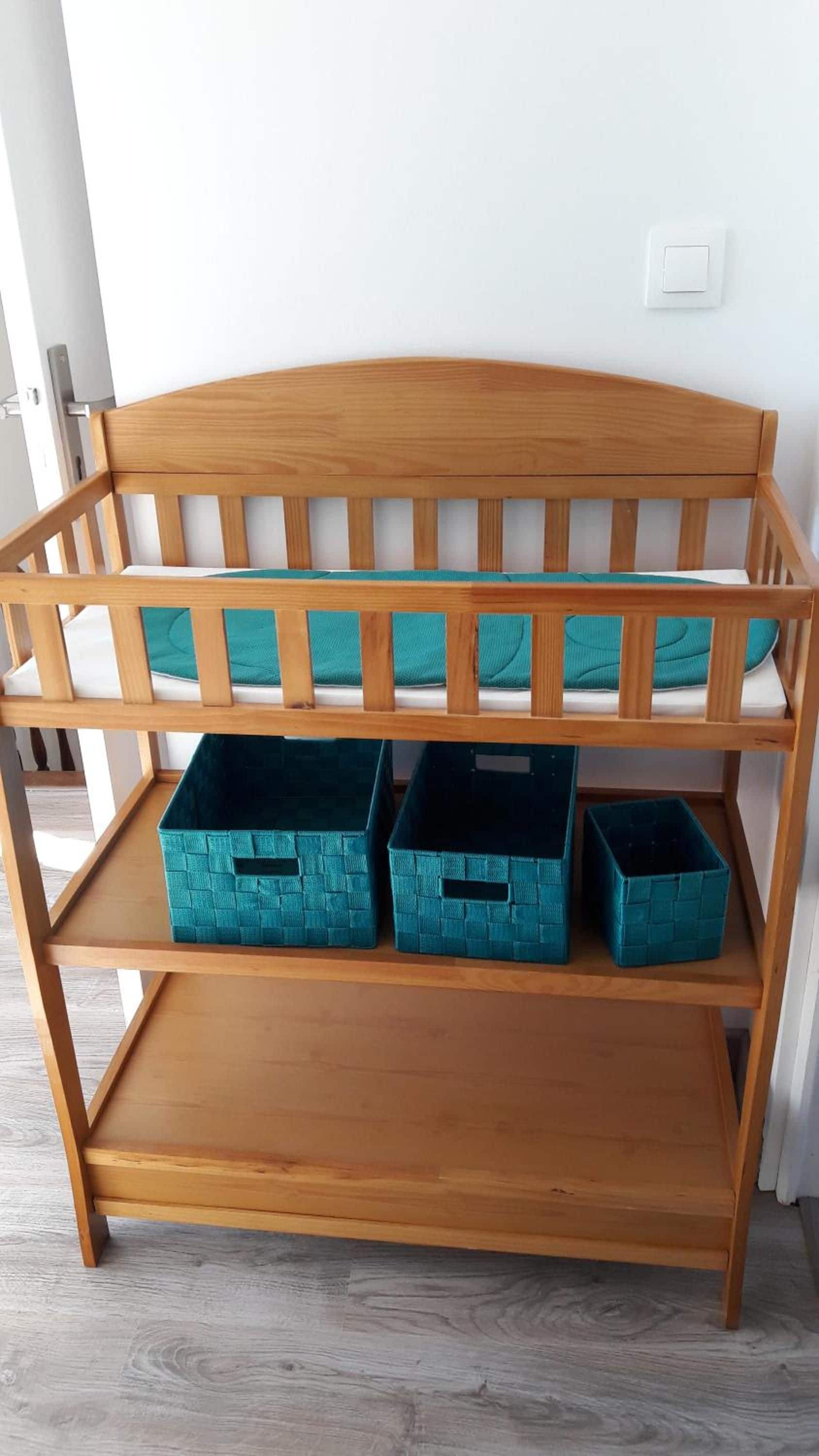 A wooden bench with a lower shelf and three storage bins.