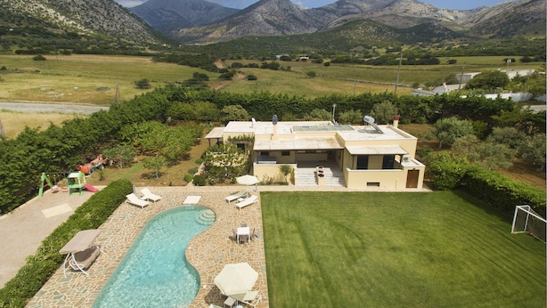 Una casa moderna amb piscina, mobiliari exterior i vista a les muntanyes.